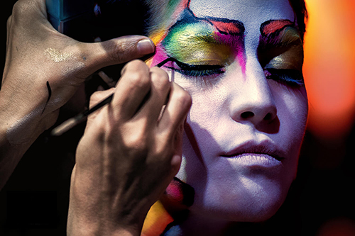 Rostro de modelo performer siendo maquillado